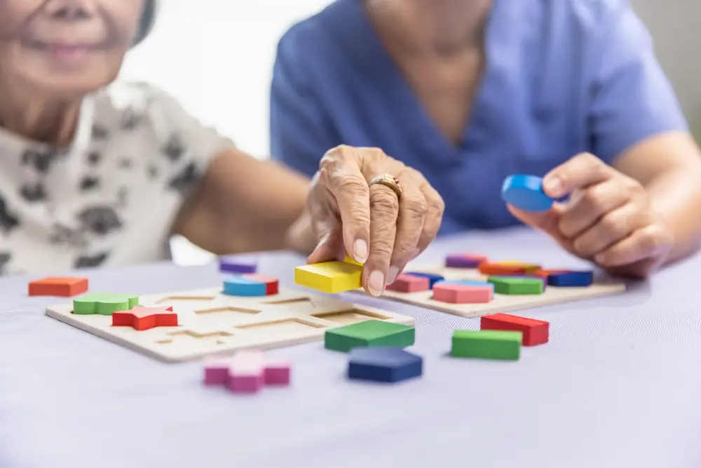 Adultos mayores realizando ejercicios de cálculo con piezas coloridas para mantener la mente activa.