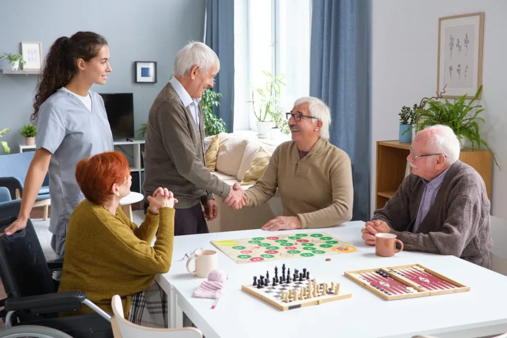 Adultos mayores disfrutando de juegos de mesa para fortalecer la memoria, la atención y fomentar la interacción social.