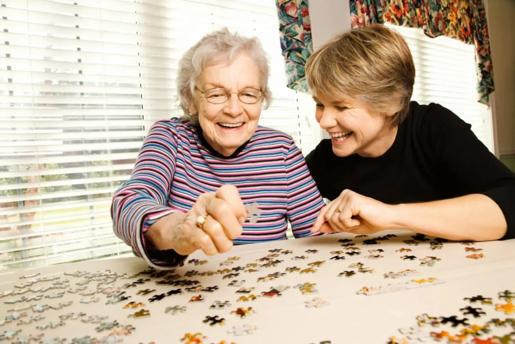 Adultos mayores armando un rompecabezas como parte de la estimulación cognitiva para adultos mayores, mejorando la concentración y la memoria visual.